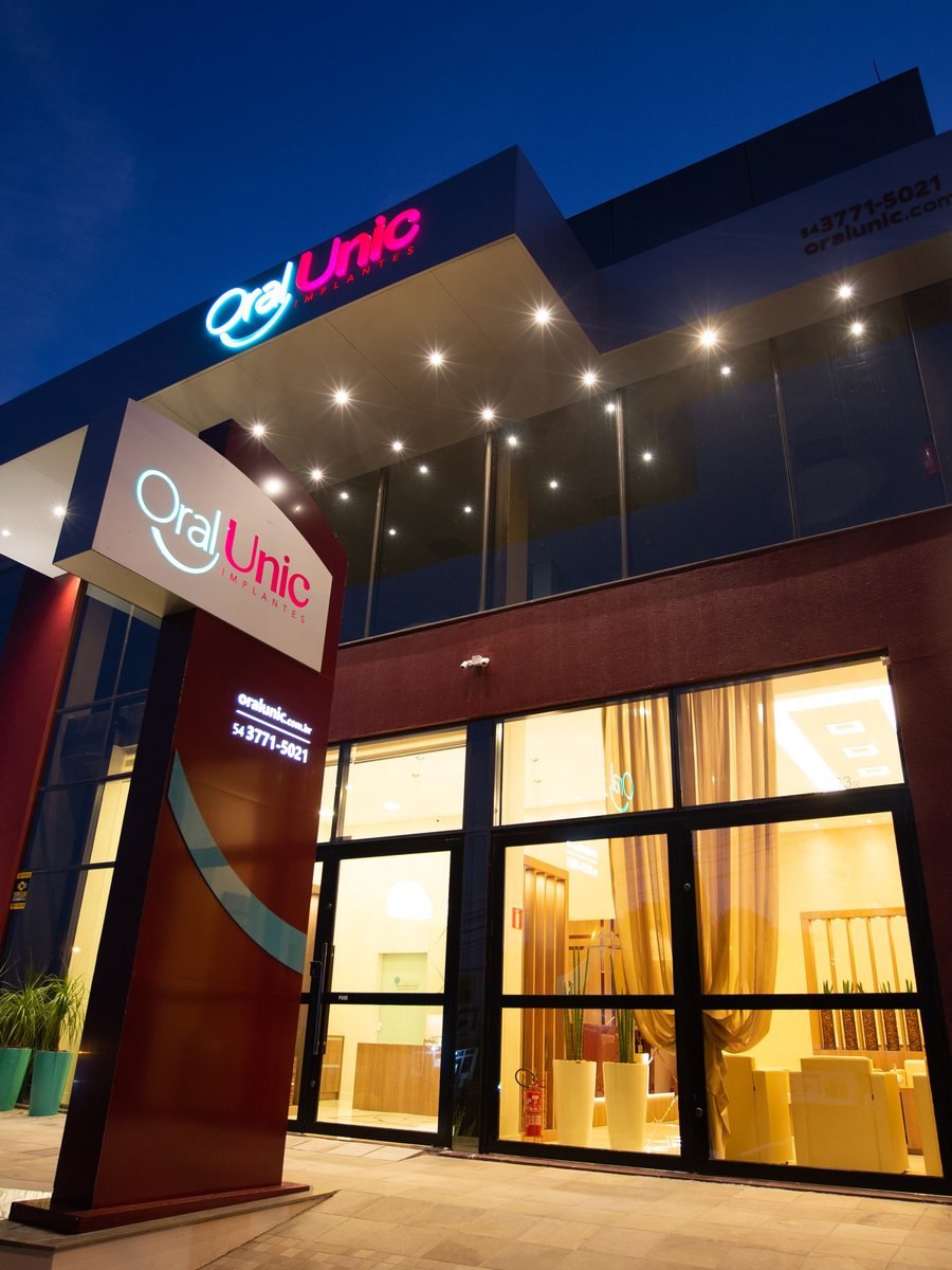 Fachada da Oral Unic Farroupilha iluminada ao entardecer